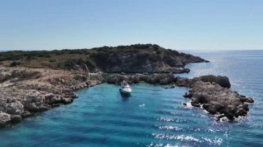 Bu hava görüntüleri ıssız bir körfezde demirlenmiş ıssız bir turist yatını çeker. Uzak bir adanın doğal güzellikleriyle çevrilidir. Aydınlık ve güneşli bir günde çekilen sahneler sakinliğini koruyor.
