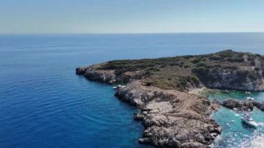 Bu İHA görüntüsü, yakınlarda demirlemiş birkaç turist yatıyla el değmemiş sularla çevrili sakin bir adayı yakalıyor. Yüksek kalite 4k görüntü