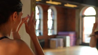 Siyah spor kıyafetli bir sporcu spor salonundaki aynaya yaklaşır, kamera hareketlerini pürüzsüz bir şekilde takip eder. Yansımasına hayran kaldıkça, sahne onun gücünü ve özgüvenini vurguluyor..