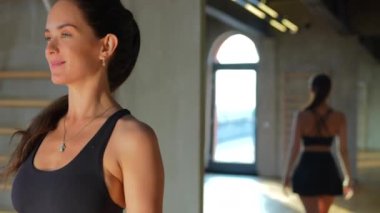 Sportif bir kız modern bir spor salonunda özgüvenini ve kararlılığını göstererek adımlarını atar. Atletik giysiler içinde, bir amaç için hareket ediyor, güçlü ve aktif bir yaşam tarzı var..