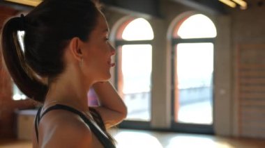 Sportif bir kız modern bir spor salonunda kendine güvenen bir poz verir, enerji ve motivasyon yayar. Atletizm kıyafetleri içinde, gücü somutlaştırıyor ve izleyicileri aktif bir yaşam tarzı sürdürmeye teşvik ediyor.