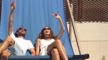 Aydınlık, gündelik giysiler giymiş neşeli bir çift canlı mavi bir bankta birlikte oturur, hayattan ve birbirlerinden hoşlanırlar. Onların rahat duruşu ve sıcak ifadeleri aşkın özünü yakalar..