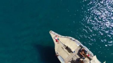 Bir yatın pruvasında dinlenen genç bir çiftin, yukarıdan geniş okyanus manzarasının tadını çıkaran barışçıl bir drone çekimi. Hava perspektifi, huzurlu atmosferi ve özgürlük duygusunu yakalar..