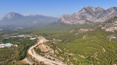 Antalyas 'ın doğal güzelliğini yakalayan nefes kesici bir dron. Arkasında görkemli dağlar olan sakin ve geniş bir orman. Yüksek kalite 4k görüntü.