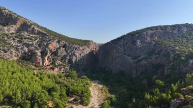 Nefes kesici bir dron yaklaşımı Kapuz Kanyonu, Antalya 'nın doğal güzelliğini yakalar. Panoramik manzara kanyon yükselen uçurumları, kristal berrak suları ve yemyeşil suları gösteriyor,