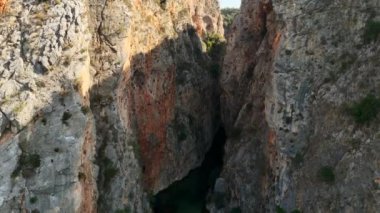 Antalya 'daki Kapuz Kanyonu' nun şeffaf turkuaz suları, engebeli uçurumları ve bereketli çevresini gösteren çarpıcı insansız hava aracı görüntüsü, Antalya 'daki Kapuz Kanyonu' nu yakalıyor. Bu panoramik çekim barışçıl bir görüntüyü ortaya çıkarıyor..