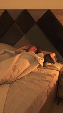 Genç bir kadın güne rahat, güneşli bir yatak odasında maskesini çıkararak huzurlu bir sabah rutini yakalayarak başlıyor.. 