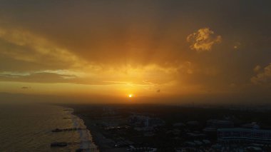 Gökyüzünü ve manzarayı aydınlatan canlı, sıcak renklerle gün batımının nefes kesen hava manzarası huzur verici ve resim gibi bir manzara yaratıyor.. 