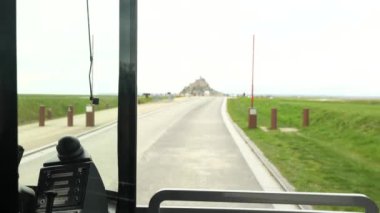 Fransa, Mont-Saint-Michel 'e yaklaşan servis otobüsü kabininden tarihi bir manzaranın görüntüsünü sunuyoruz..