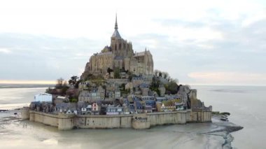 Mont Saint-Michel Manastırı ve ortaçağ köyü Normandiya 'da gün batımında güzelce aydınlatılarak çarpıcı ve tarihi bir manzara sunuyor.. 
