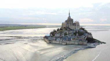 Gelgit sularıyla çevrili Mont Saint-Michel manastırı, ortaçağ mimarisi ve doğal manzaranın çarpıcı bir karışımını vurguluyor..