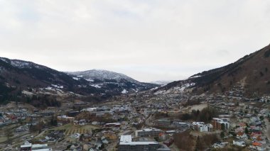 An aerial shot of Sogndal, Norway, featuring a peaceful winter town nestled between snowy mountains and scenic valleys. clipart