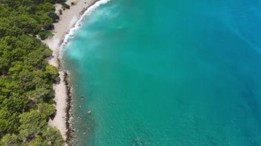 Türkiye 'nin Antalya kentindeki güzel bir kıyı manzarası, ormanlık tepeler ve geniş bir okyanus manzarasıyla doğal huzuru vurguluyor.