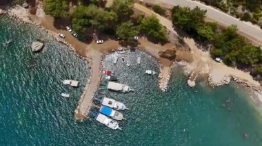 Türkiye 'nin Antalya kentindeki kayalık bir kıyı şeridine yanaşan teknelerin hava manzarasında berrak sular ve çarpıcı kıyı manzarası görülüyor.. 