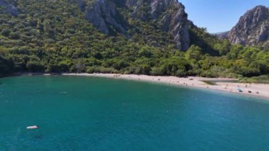 Göz kamaştırıcı panoramik manzara kristal berrak suyla çevrili, kayalık dağlarla çevrili, doğal sükunet sunan güzel bir sahil.. 