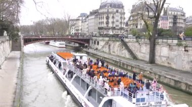 Paris, Fransa 7 Aralık 2024 Bir turist teknesi Seine Nehri boyunca seyahat ediyor, ikonik simgeler ve mimari manzaralar sunuyor.. 