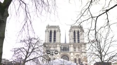 Paris 'teki Notre Dame Katedrali' nin ikiz kuleleri. Güzel çerçevelenmiş çıplak kış ağaçları. Gotik zarafet ve cazibe sergiliyorlar..