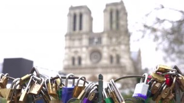 Paris Köprüsü 'nde renkli aşk kilitleri. Arka planda Notre Dame Katedrali tarafından çerçevelenmiş romantizmi ve bağlılığı sembolize ediyor..