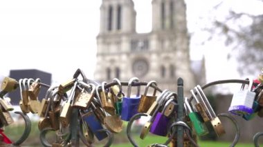 Renkli aşk kilitleri Paris köprüsüne bağlanmış ikonik Notre Dame Katedrali arka planda çok güzel görünür.