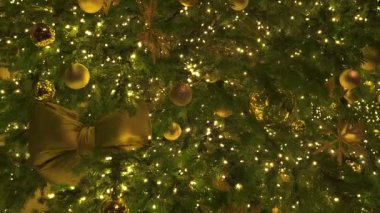 Altın süslerle süslenmiş güzel bir Noel ağacı, ışıl ışıl ışıklar, ve bayram havası yaratan şenlikli detaylar.. 