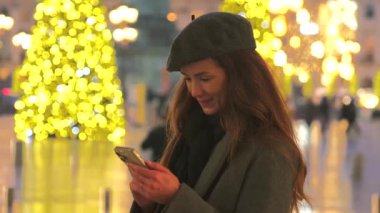 Genç bir kadın, Paris 'teki Place Vendome' da bayram süsleriyle çevrili parıldayan Noel ışıklarına hayran kalarak gülümsüyor.. 