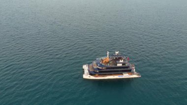 Türkiye, Antalya 08.08.2024 Akdeniz 'de akşam saatlerinde sakin suları ve altın gökyüzü ile lüks bir yata yaklaşan bir insansız hava aracının çarpıcı görüntüsü.. 