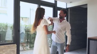 Neşeli bir çift, doğal ışıkla dolu, parlak ve modern bir iç mekanda, keyifli bir dansı mutlulukla paylaşıyor.