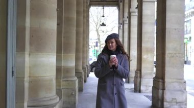 Bereli bir kız Paris 'in göbeğinde elinde bir fincan kahveyle geziyor. Kraliyet Sarayı' nın tarihi sütunlarının yanında. Ebedi Fransız zarafetini temsil ediyor..