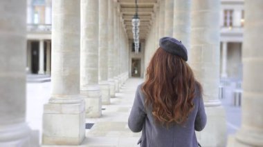 Gri paltolu ve bereli bir kız elinde bir fincan kahveyle Paris 'teki tarihi sütunlar arasında yürüyor. Ebedi zarafet ve Fransız cazibesi yayıyor..