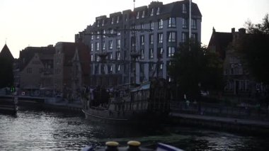 Gdansk, Polonya. 25.04.2024 Gün batımında kıyıya yaklaşan bir geminin çarpıcı görüntüsü, sakin denizi yansıtan altın renkleri, barışçıl ve manzaralı bir sahil atmosferi yaratır.