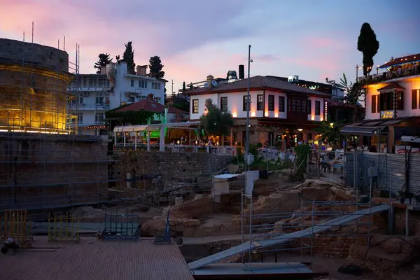 Antalya Türkiye 21.09.2025 Antik harabeler, tarihi binalar ve renkli bir günbatımı gökyüzü ile çevrili, eski şehrin akşam ışıkları altında parlayan rahat restoranların yanı sıra. 