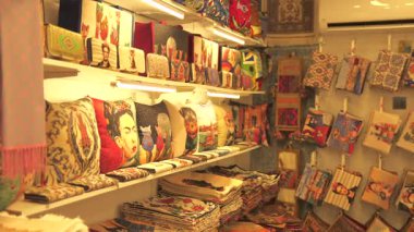 Türkiye, Antalya 10 Ekim 2024 renkli bir pazarda sanatsal ve geleneksel desenlere sahip el yapımı tekstil çantaları, dekoratif yastıklar ve kumaş aksesuarları sergileniyor.