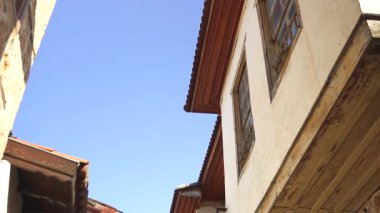 Türkiye, Antalya 10 Ekim 2024 Eski bir kasabada ahşap balkonların, taş duvarların ve geleneksel mimarinin yer aldığı tarihi Osmanlı tarzı evlerle dolu pitoresk bir dar sokak.