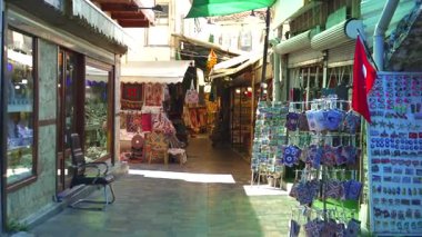 Türkiye, Antalya 10 Ekim 2024 Geleneksel bir pazarda el yapımı tekstil, mücevher, kartpostal ve hediyelik eşya satan bir ara sokak, canlı ve kültürel bir alışveriş deneyimi yaratıyor.