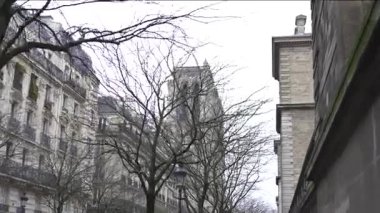 Paris 'teki Notre Dame Katedrali' nin ikonik kulesi, gotik güzelliğini ve tarihi çekiciliğini ön plana çıkaran çıplak kış ağaçları tarafından çerçevelenmiştir..