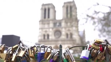 Paris Köprüsü 'nde renkli aşk kilitleri. Arka planda Notre Dame Katedrali tarafından çerçevelenmiş romantizmi ve bağlılığı sembolize ediyor..