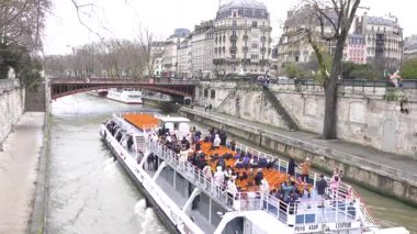 Paris, Fransa 7 Aralık 2024 Bir turist teknesi Seine Nehri boyunca seyahat ediyor, ikonik simgeler ve mimari manzaralar sunuyor.. 