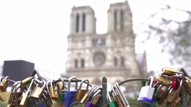 Paris Köprüsü 'nde renkli aşk kilitleri. Arka planda Notre Dame Katedrali tarafından çerçevelenmiş romantizmi ve bağlılığı sembolize ediyor..