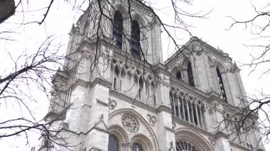 Paris 'teki Notre Dame Katedrali' nin ikonik cephesi, narin kış dalları tarafından çerçevelenmiş, gotik mimari ve cazibeyi gözler önüne seriyor..