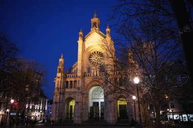 Brüksel Belçika 03.25.2025. Mavi saatte Saint Catherine Kilisesi 'nin önü. Sıcak ışıklarla parlıyor ve çıplak kış ağaçları çerçeveli.. 