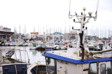Boulogne. Fransa 03.28.2025. Kalabalık bir marinaya kenetlenmiş bir balıkçı teknesinin yakın görüntüsü. Arka planda birçok eğlence teknesi ve liman binası var..