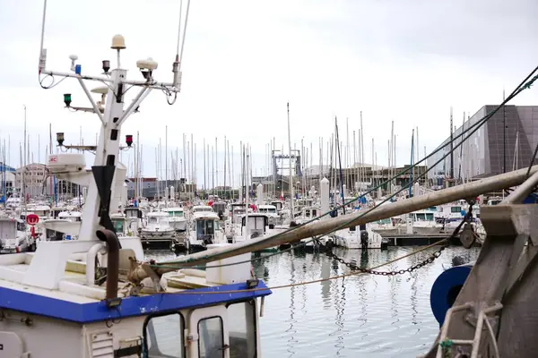 Boulogne. Fransa 03.28.2025 Halat ve donanımlı bir balıkçı teknesinin ön planı, yat ve küçük teknelerle dolu kalabalık bir marinaya bakıyor..