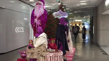 Paris, Fransa 02.20.2025 Galeriler Lafayette 'de pembe mankenler, ışıltılı Noel Baba ve 130. Noel' i kutlayan canlı aksesuarların yer aldığı renkli bir Noel düzeneği..