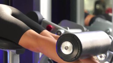 Beden eğitiminde bacak pres makinesi kullanan, vücut eğitimine odaklanan ve modern spor ayakkabılarını eylem sırasında sergileyen kişinin detaylı görüntüsü. 