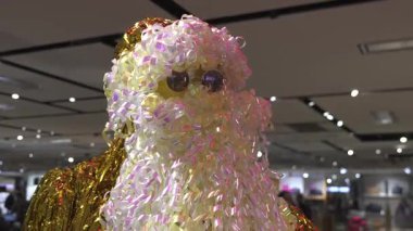 Çağdaş dekoratif Noel Baba figürü parlak bukleler ve süslemelerden yapılmıştır. Parlak perakende mağazasının altında sergilenmektedir..