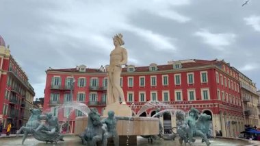 Güzel, Fransa 04.15.2025 Apollo 'nun su figürleriyle çevrili ikonik Fontaine du Soleil, Place Massena' daki renkli tarihi binalara karşı hazırlanıyor.