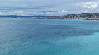 Güzel, Fransa 04.15.2025 Parlak, güneşli bir gökyüzünün altında çakıllı sahil ve turkuaz sularıyla Avlu Güvertesi 'nin geniş açılı görüntüsü..