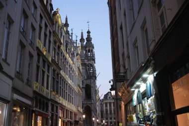 Bruxelles, Belçika 04.01.2025 Altın aksanlı tarihi binalar büyüleyici bir alışveriş caddesinden görünen Grand Place 'in süslü kulelerine çıkar.. 