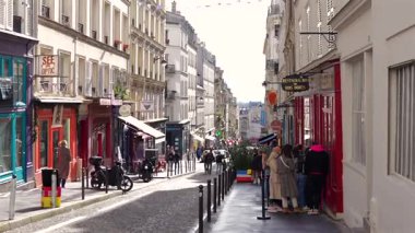 Paris, Fransa 04.01.2025 İnsanlar Montmartre Paris 'in renkli bir caddesi boyunca, dükkanlar, kafeler ve tipik Paris mimarisi ile çevrili iyi bilinen bir lokantada sıraya girerler. Sadece editör kullanımı. 