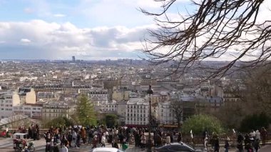 Paris, Fransa 04.01.2025 Büyük turist grubu, açık mavi gökyüzü altında şehrin çatılarına, siluetine ve kentsel manzaraya bakan Montmartre bakış açısında toplandı. Sadece editör kullanımı. 